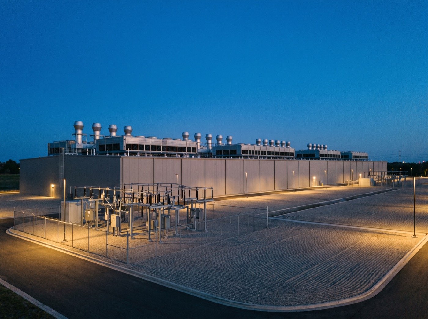 Data centre building with rooftop cooling units at blue hour