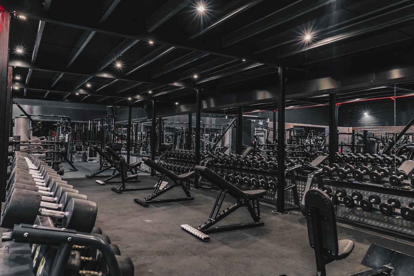 Dumbbell racks and benches on a gym training floor