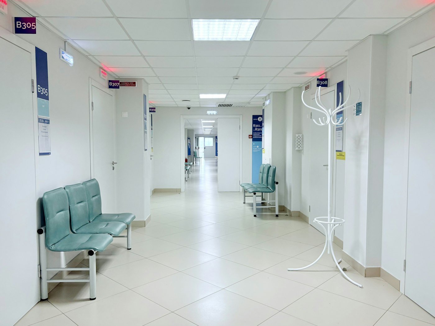 A bright medical clinic corridor lined with consulting rooms