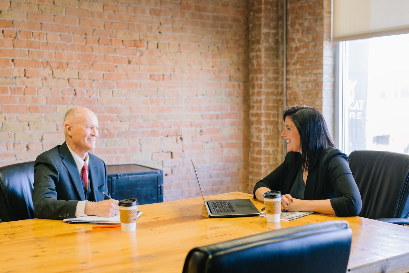 Two people talking across a desk in an office