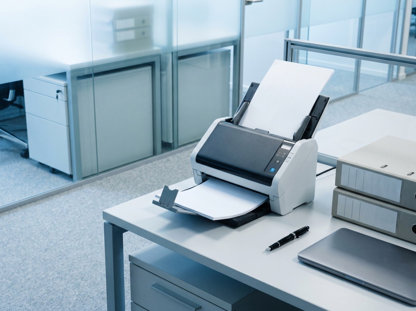 Document scanner and archive boxes on a modern office desk