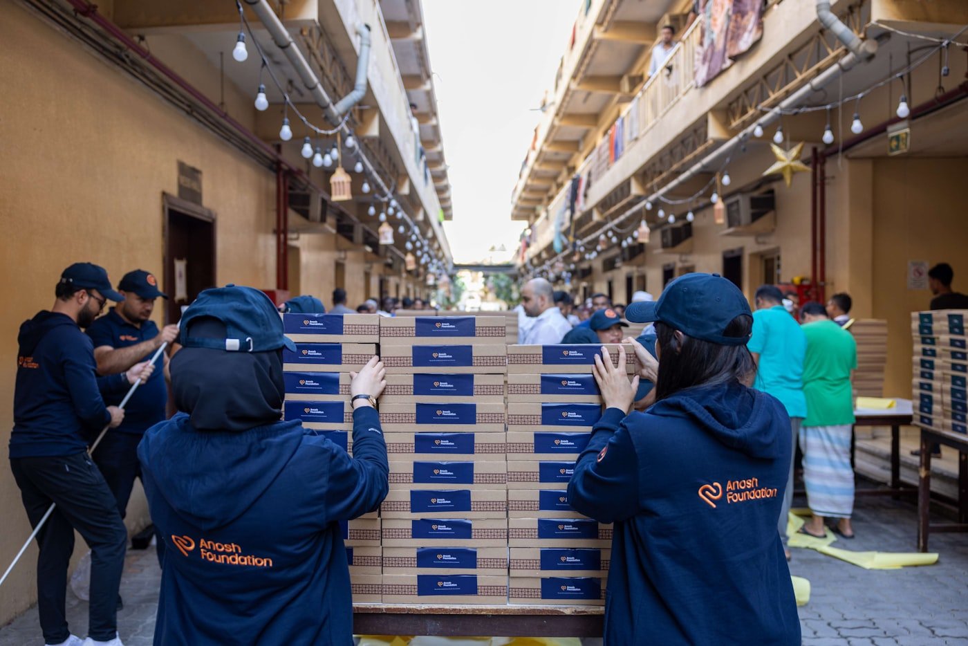 Volunteers stacking boxes of food at a community drive