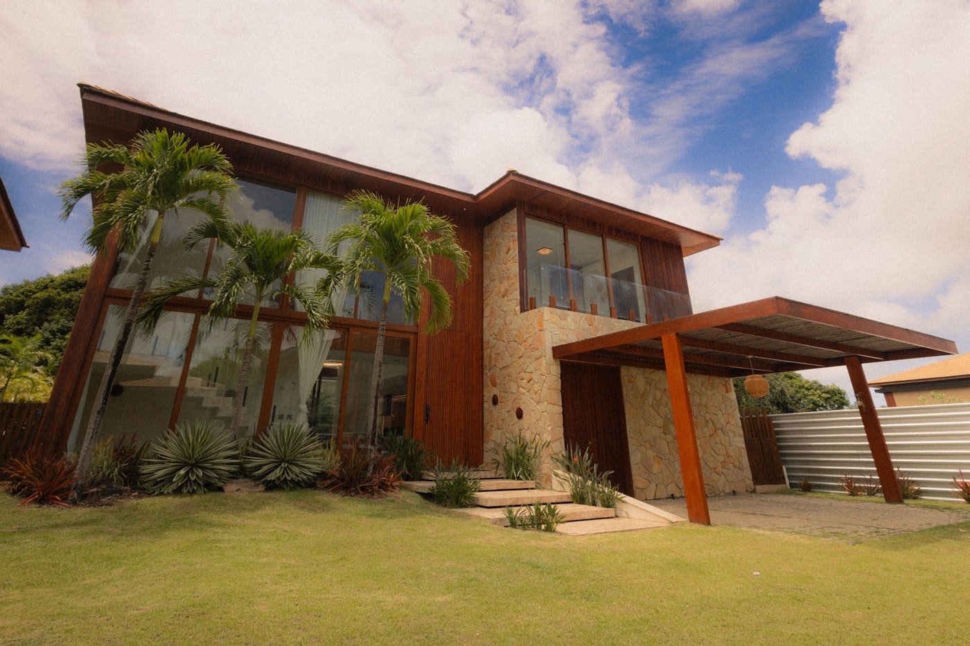 A modern house exterior clad in wood and natural stone