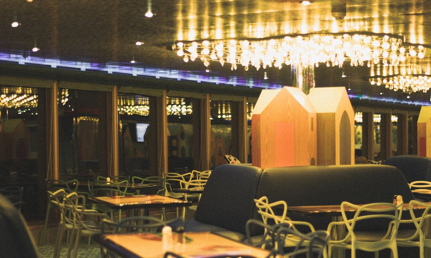 A warmly lit restaurant dining room with set tables