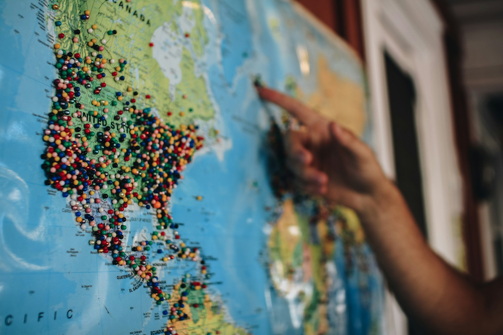 A person pointing at a paper map with location pins — multi-channel local discovery
