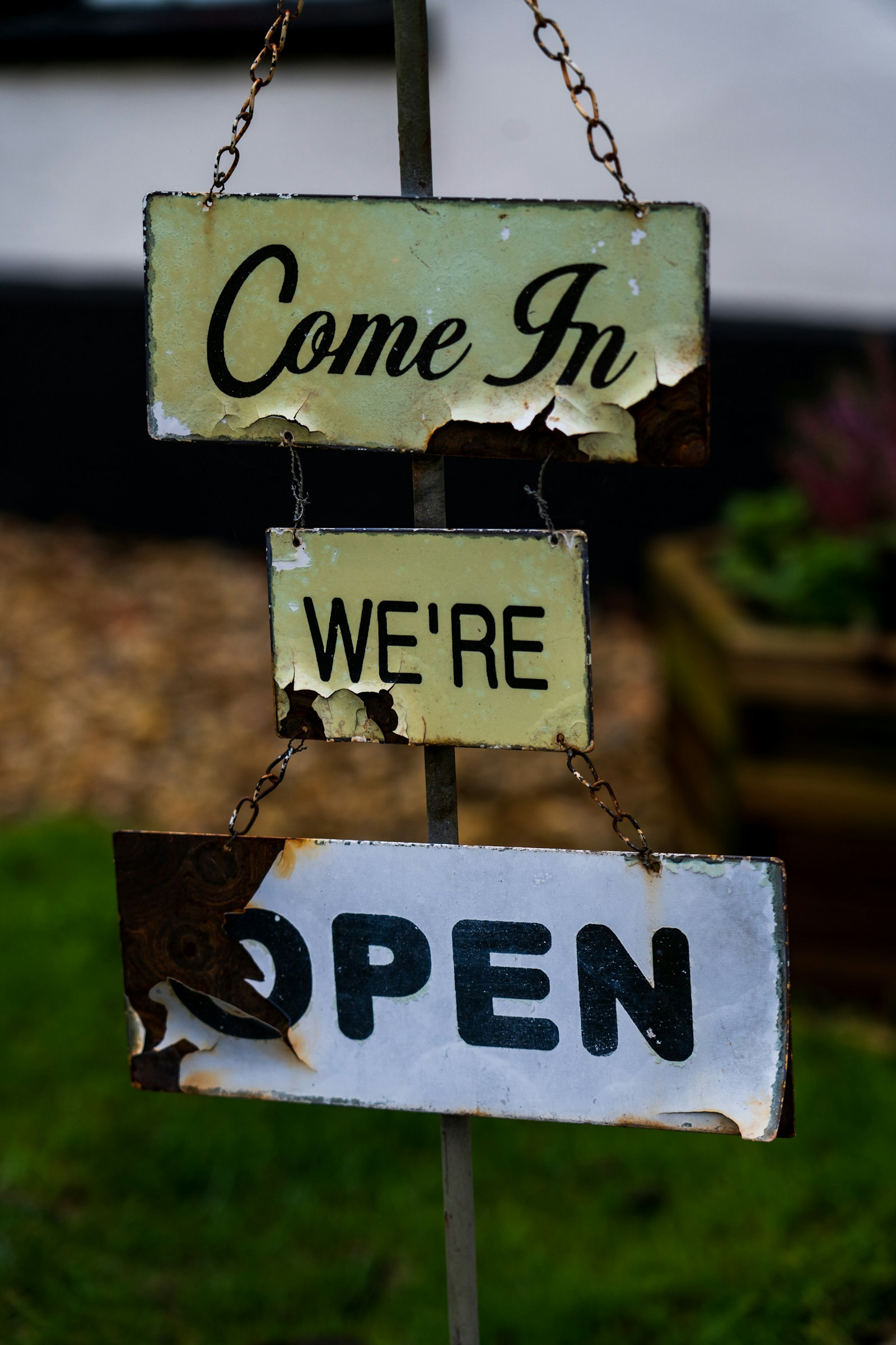 "Come in, we are open" sign hanging in a small business storefront window